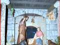 Escena de la Natividad con figuras de la Virgen María y San José, animales y frutas, representando el nacimiento de Jesús.