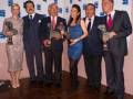 Celebridades posan con sus premios en la alfombra roja.