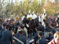 Desfile de soldados a caballo y banda de música en una celebración pública.