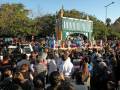 Desfile festivo con carroza y multitud en una celebración al aire libre.