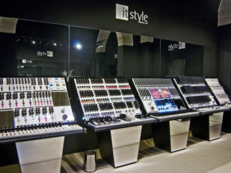 Un estudio de grabación profesional con varios controles de mezcla en fila, iluminado por luces blancas y con una pantalla de 'it style' en el fondo.