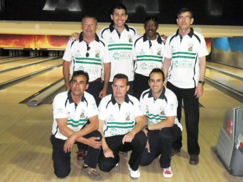 Equipo de bowling con uniformes blancos y verdes, posando en una pista de bowling.