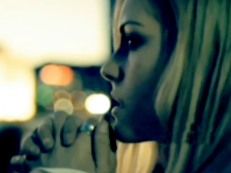 Close-up of a person's face, focusing on the mouth and part of the nose, with a blurred background of warm lights.