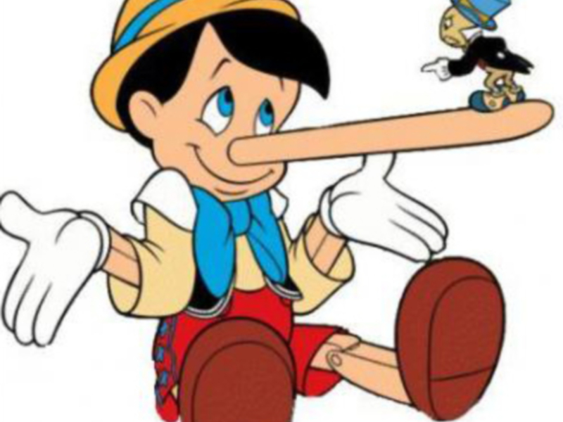 Pinocchio, con su nariz larga y roja, se encuentra en una escena de la película. Su expresión es triste mientras mira hacia arriba, y detrás de él, se ve a Jiminy Cricket con su típica sombrero azul.