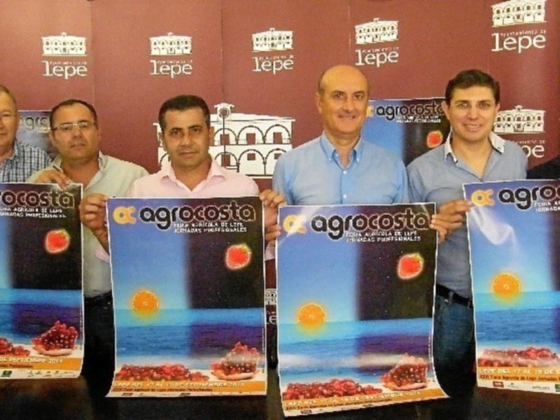 Grupo de personas posando con pósteres de Agrocosta en una presentación en Lepe.