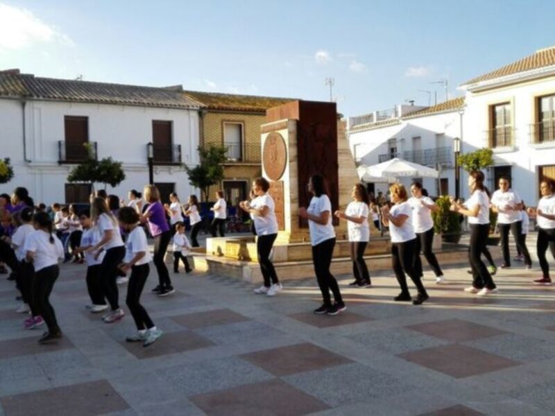 Grupo de personas realizando ejercicio en una plaza al aire libre.