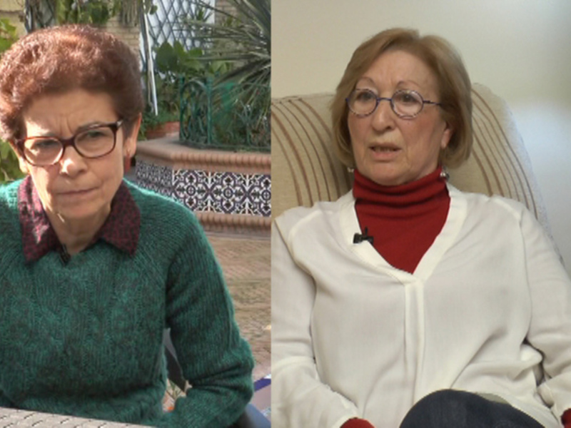 Dos mujeres sentadas, una en un jardín con plantas y la otra en un sofá interior, ambas con expresiones serias.