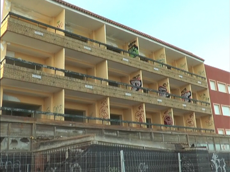 Fachada de un edificio con balcones y graffitis en varios pisos
