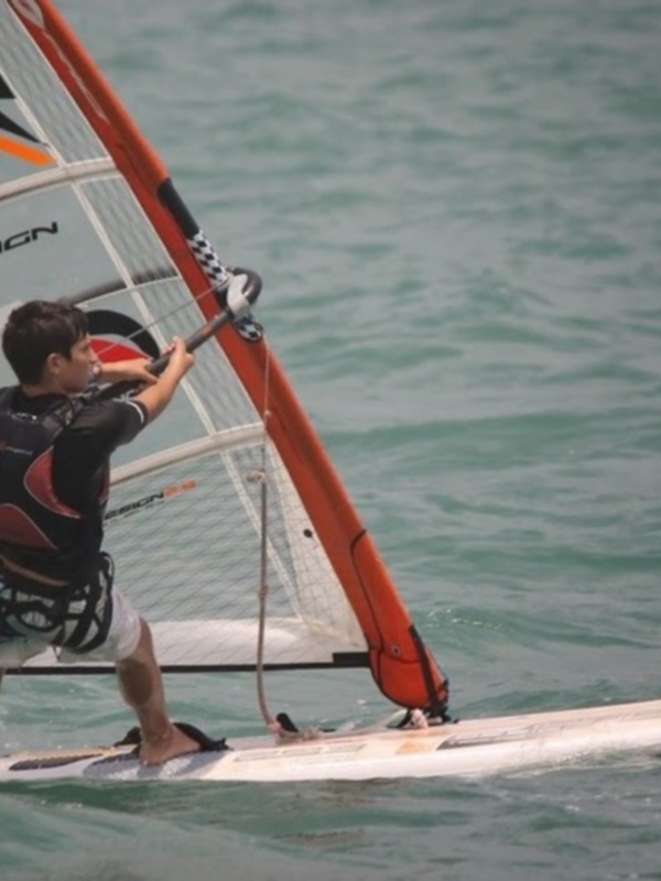 Un windsurfer en acción, navegando con habilidad sobre las olas del mar.