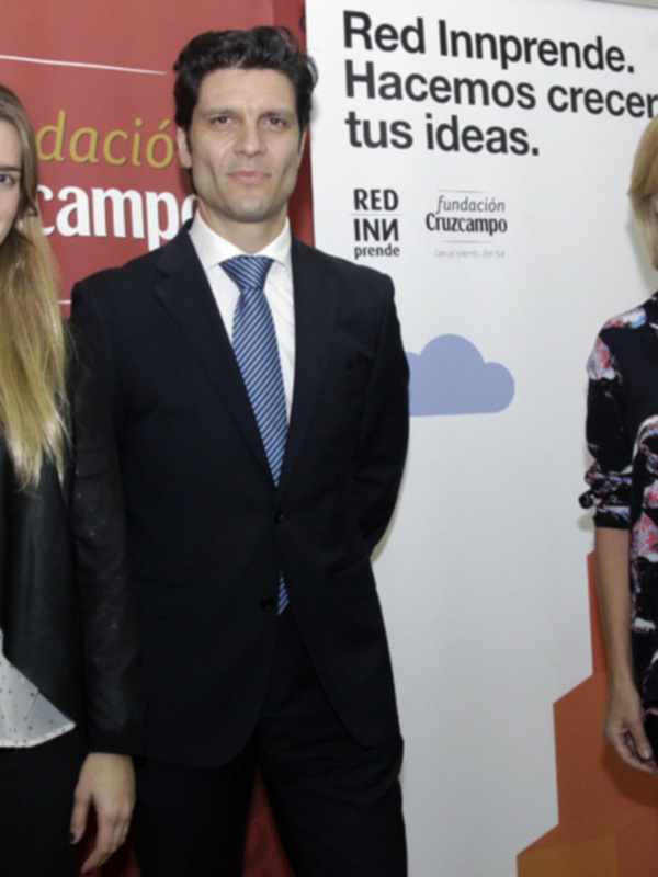 Tres personas posan frente a un fondo con carteles de la Fundación Cruzcampo y el lema "Red Inprende. Hacemos crecer tus ideas."