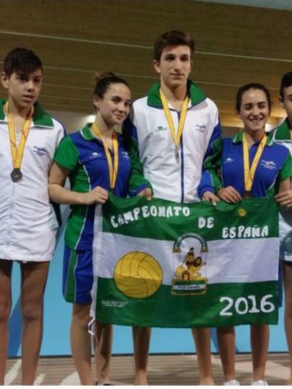 Equipo de natación celebrando el Campeonato de España de 2016, con medallas y bandera nacional.