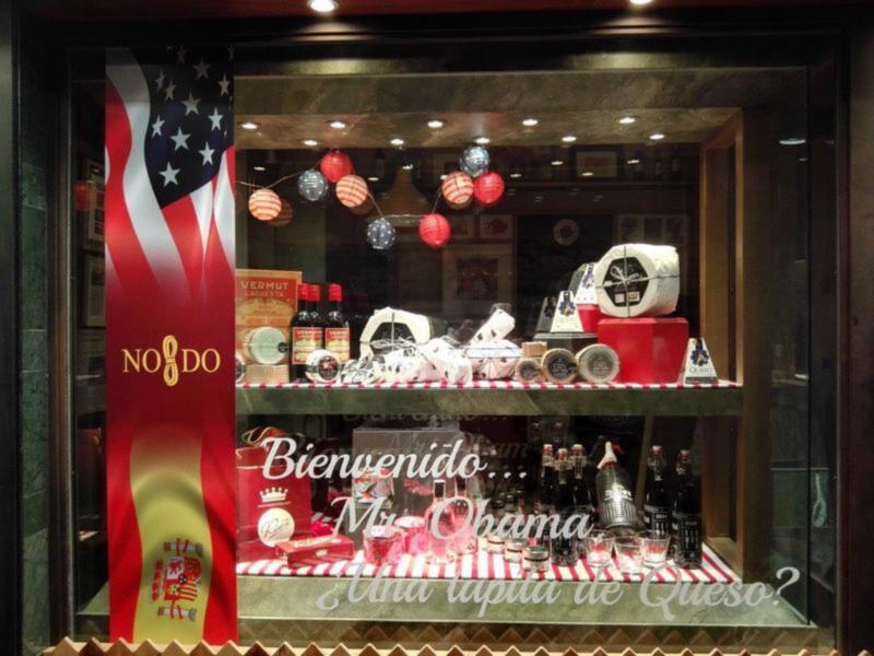 Una tienda de bebidas con una bandera española y un mensaje en español: 'Bienvenido, Obama'.