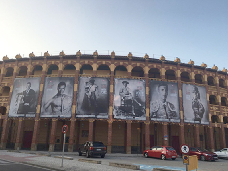 Estadio de toros con carteles de famosos en la fachada