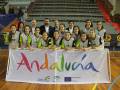Equipo de baloncesto femenino posando en cancha con un banner que dice "Andalucía" y "Unión Europea".