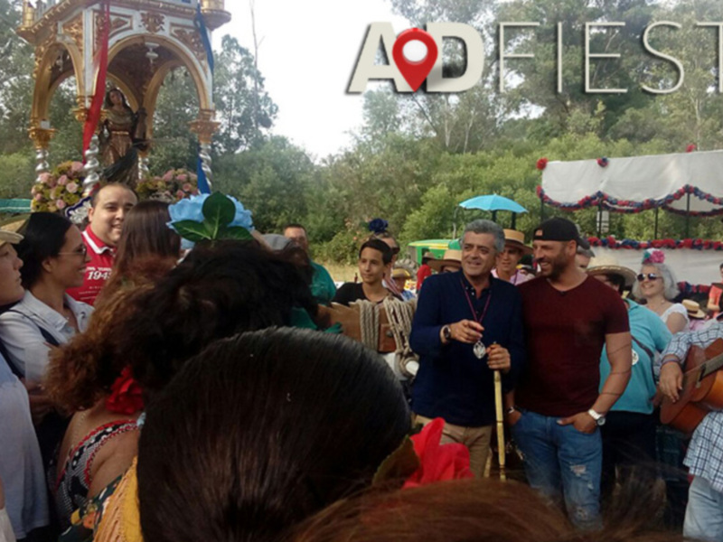 Fiesta celebración con personas en el parque, música y disfraces festivos.