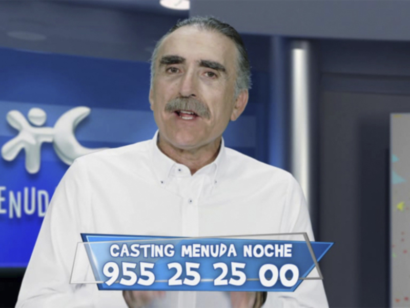 Un hombre en una producción de televisión con un logo de 'Menuda Noche' en el fondo.