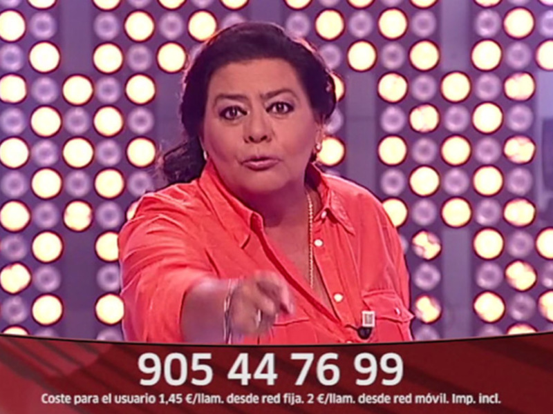 Una presentadora en un estudio de televisión con luces detrás y un teléfono de contacto en la pantalla.