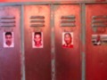 Las puertas de un armario metálico rojo están cubiertas con fotos de personas. La puerta central tiene dos fotos, mientras que las otras dos tienen una sola foto cada una. El armario parece estar en un lugar público, posiblemente en un instituto o centro de estudios.