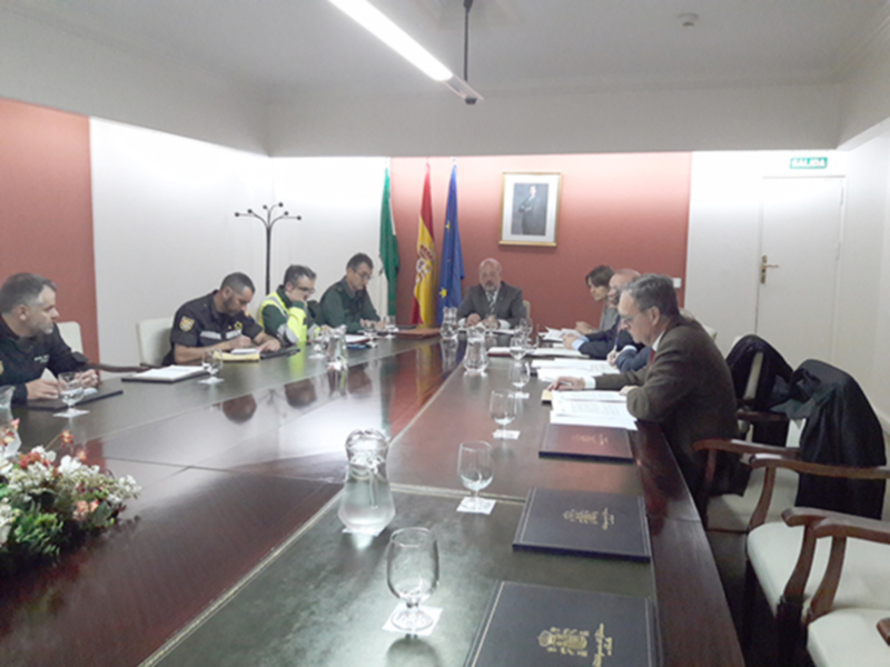 Reunión de trabajo en una sala de conferencias con banderas y documentos en mesa.