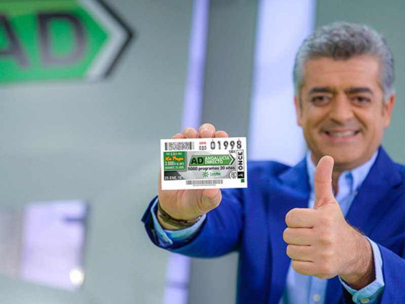 Hombre mostrando un billete de la ONCE con un gesto positivo.