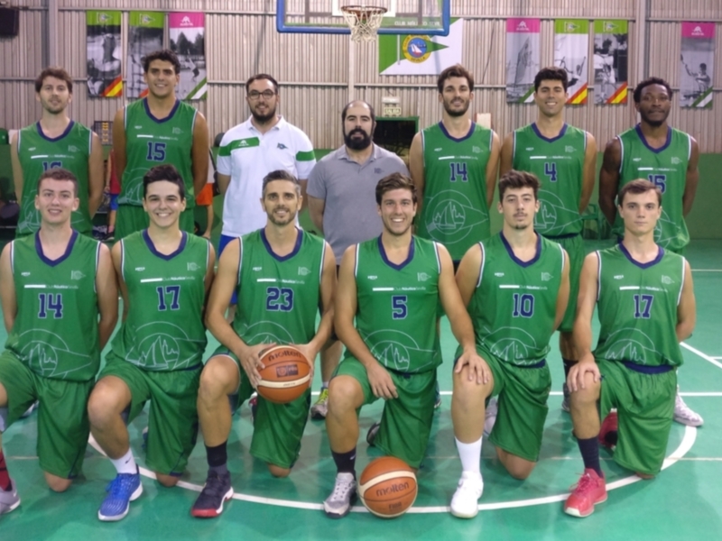 Equipo de baloncesto con uniformes verdes y detalles azules, posando en la cancha de baloncesto.