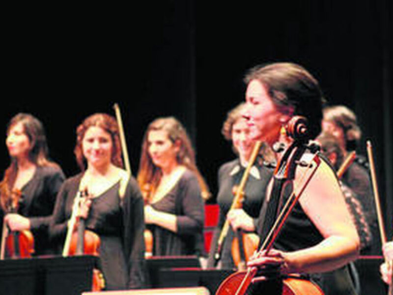 Orquesta sinfónica femenina en concierto, interpretando música clásica.