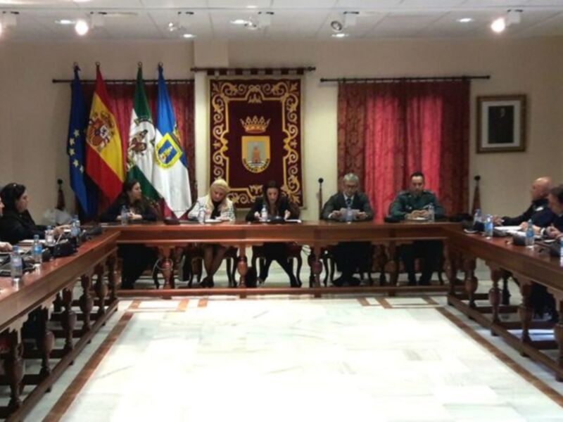 Reunión formal en una sala de conferencias con banderas y decoración oficial.