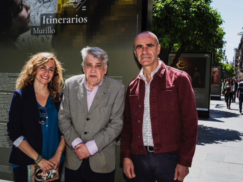 Personas frente a un cartel con información sobre Itinerarios Murillo.