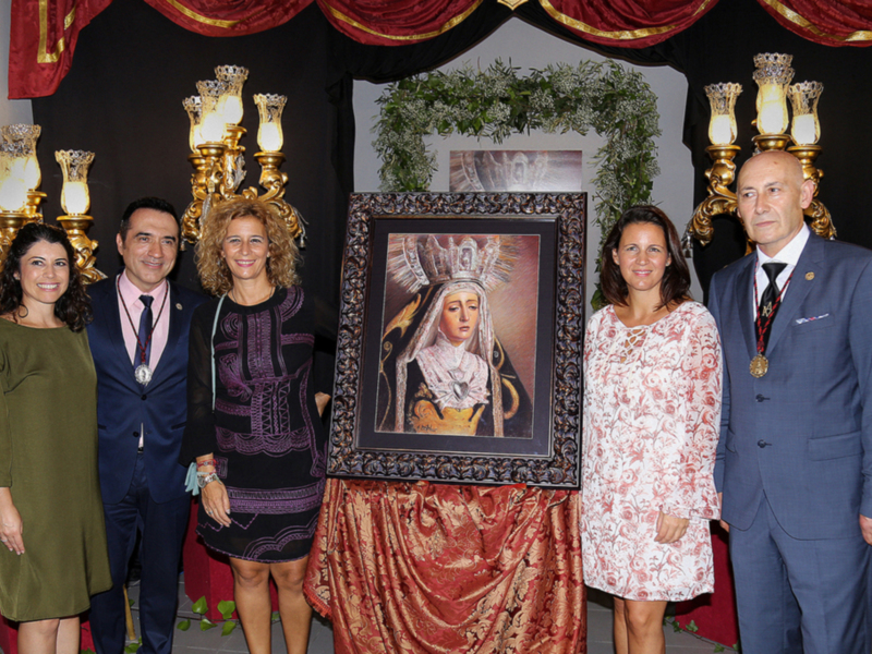 Celebración con autoridades y una imagen religiosa en un entorno formal y decorado.