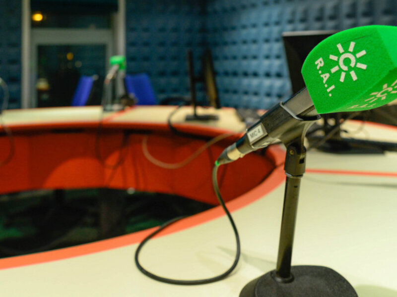 Un micrófono con una etiqueta verde que dice "RÁL" en un estudio de radio.