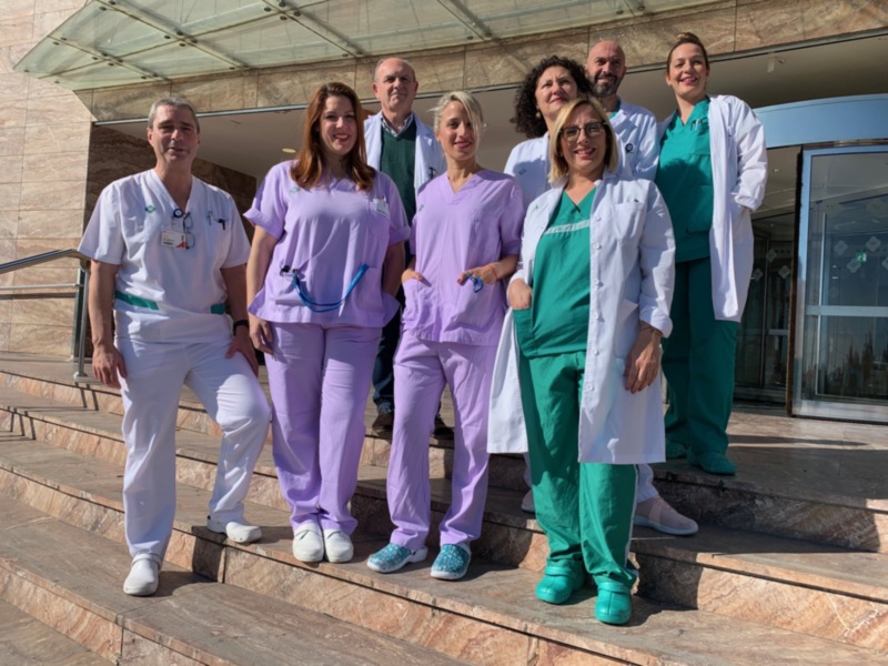 Equipo médico en un hospital, posando en la entrada.