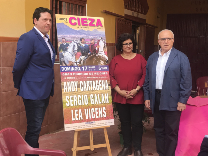 Presentación de la corrida de toros en Cieza, con carteles promocionales y tres personas posando frente a ellos.