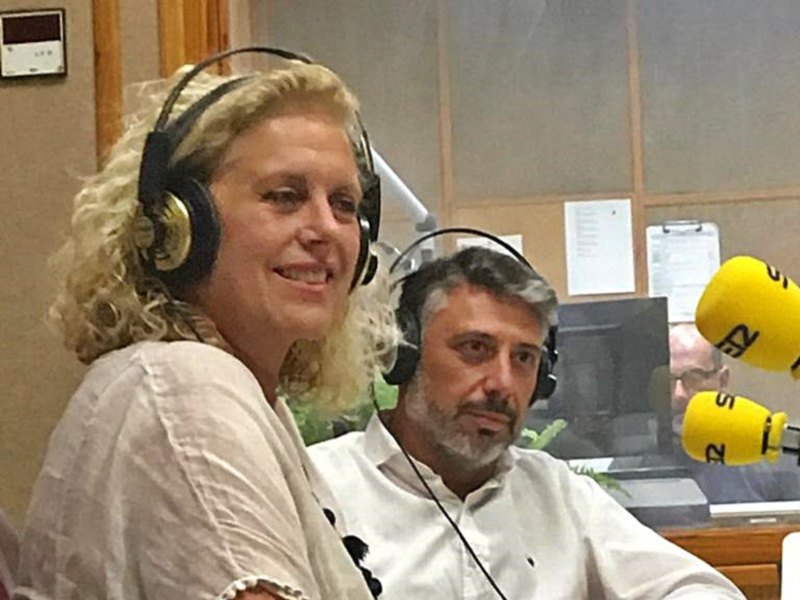Dos personas en un estudio de radio, una con auriculares y la otra con un micrófono amarillo.
