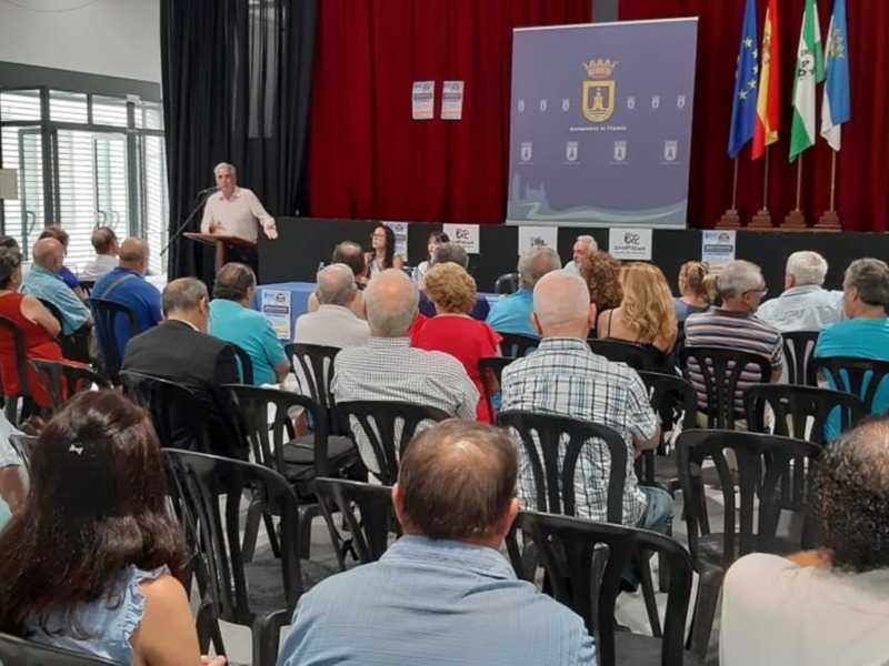 Conferencia pública en un salón con audiencia atenta.