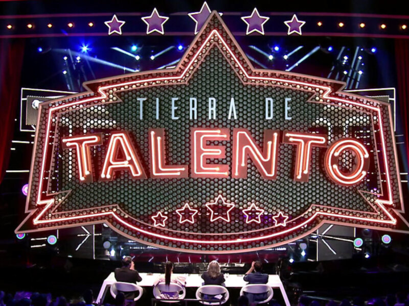 Escenario de un programa de talentos con un telón de fondo en forma de estrella y luces brillantes. El escenario está preparado para una presentación de talentos.