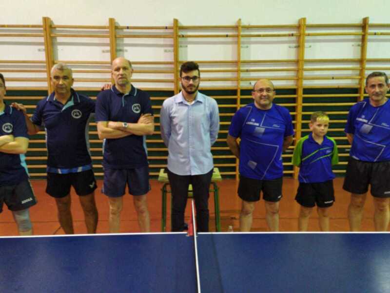 Equipo de tenis de mesa posando en el gimnasio