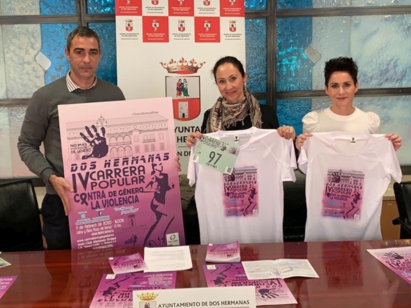 Presentación de la IV Carrera Popular contra la Violencia de Género en Dos Hermanas, con carteles promocionales y camisetas de la carrera.