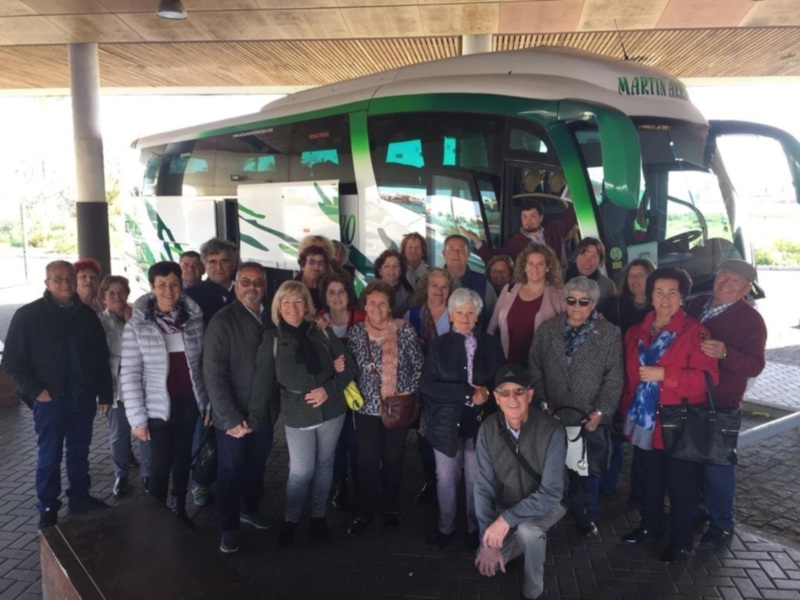 Grup de persones davant un autobús a la parada.