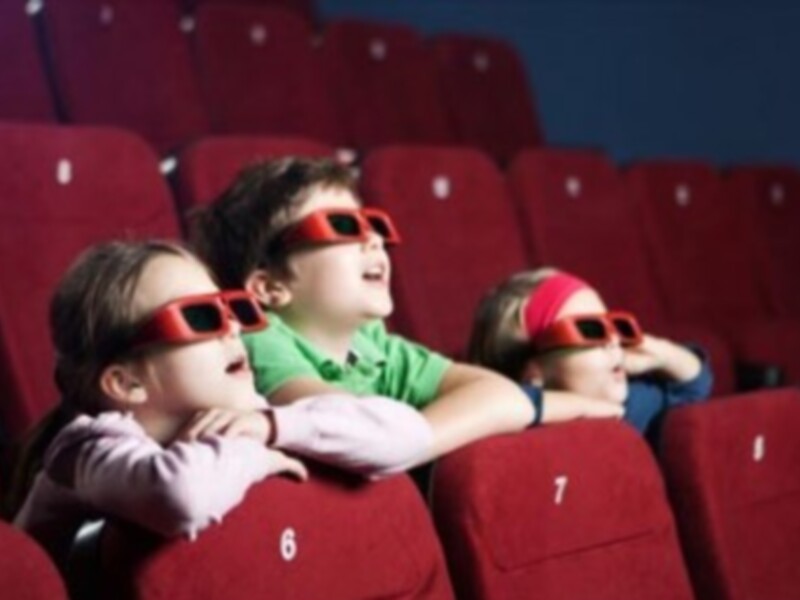 Niños con gafas 3D en una sala de cine.