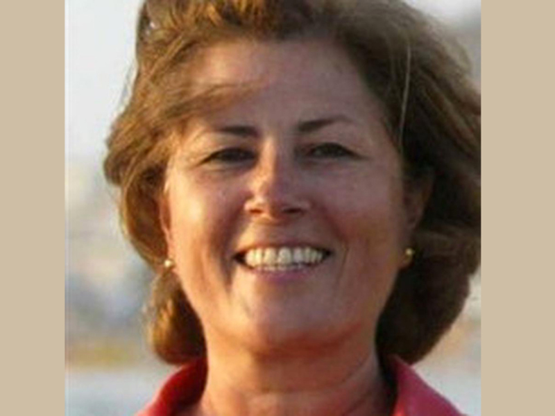 Una mujer con cabello rojo y una camisa roja sonriendo.