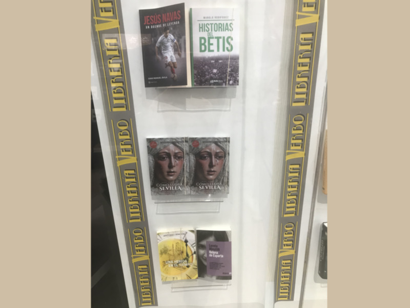 "Libros sobre la historia del Sevilla y Betis en una vitrina."