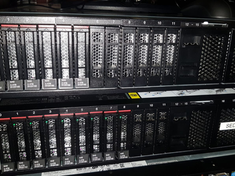 Un rack de servidores con discos SAS de 2.4TB y 3.0TB. El rack está etiquetado con 'SEDE ELECTRIC' en la parte superior.