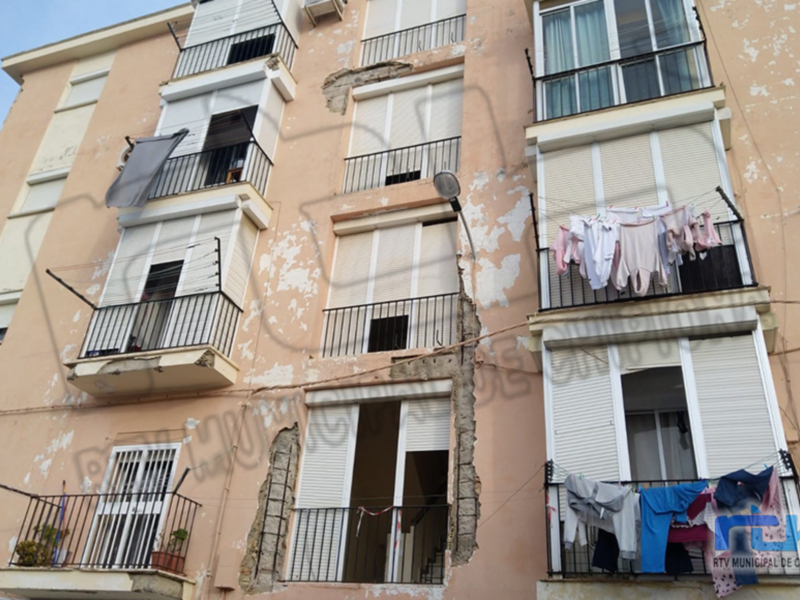 Fachada de un edificio con balcones y ropa colgando en los balcones.