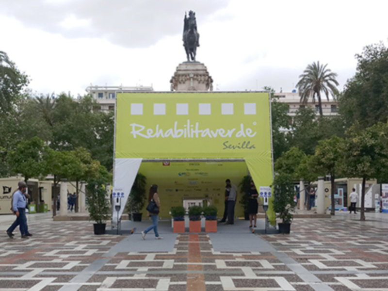 Stand informativo sobre rehabilitación en la Plaza de España, Sevilla.