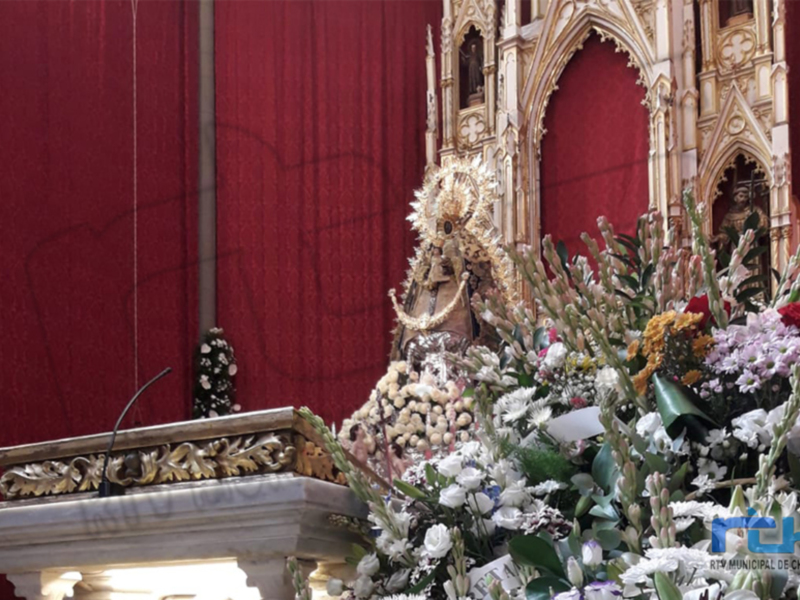 Un altar en una iglesia con flores y un rostro tallado.