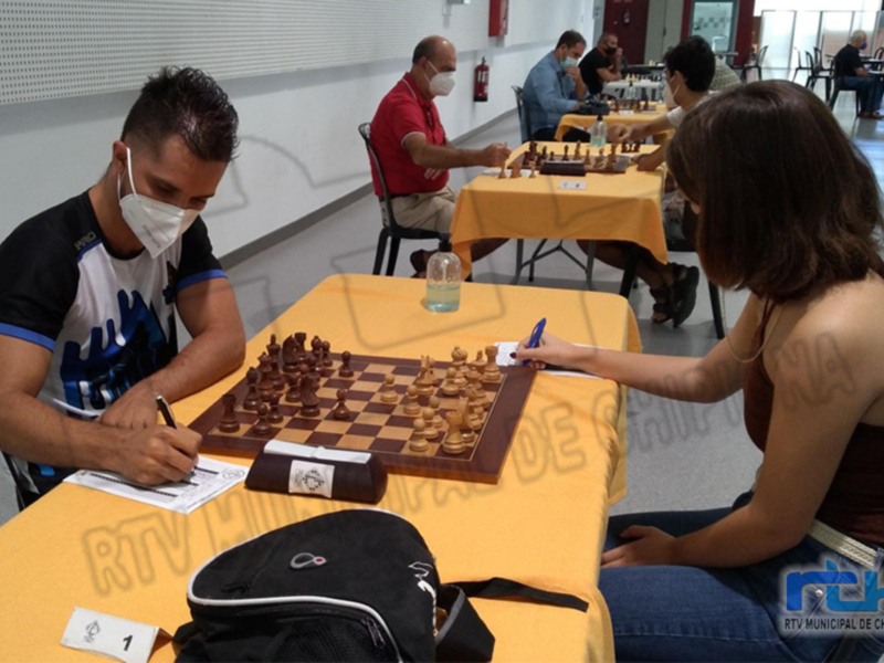 Jugadores de ajedrez en una competencia, todos con mascarillas, en un ambiente controlado para prevenir el COVID-19.