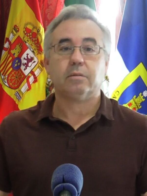 Persona hablando en rueda de prensa con banderas españolas y europeas al fondo.