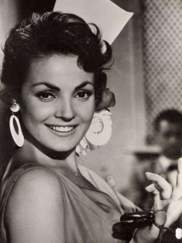Vintage black and white photo of a woman with a stylish hairstyle and large earrings.