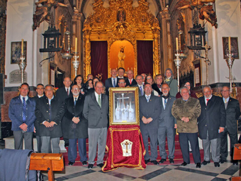Celebración en una iglesia con un grupo de personas posando frente a un altar con una imagen religiosa