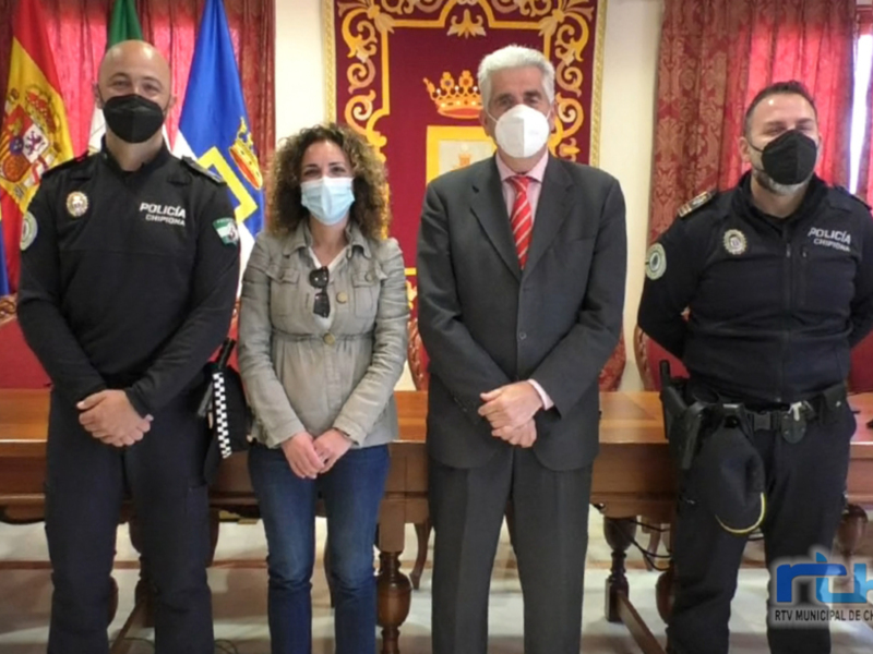 Reunión oficial con autoridades locales y policías en un entorno formal con banderas y decoración oficial.